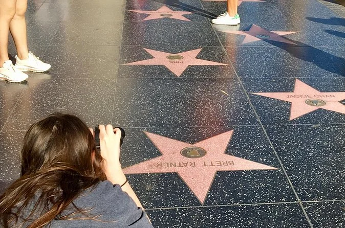 Un visiteur photographiant des étoiles sur le Walk of Fame